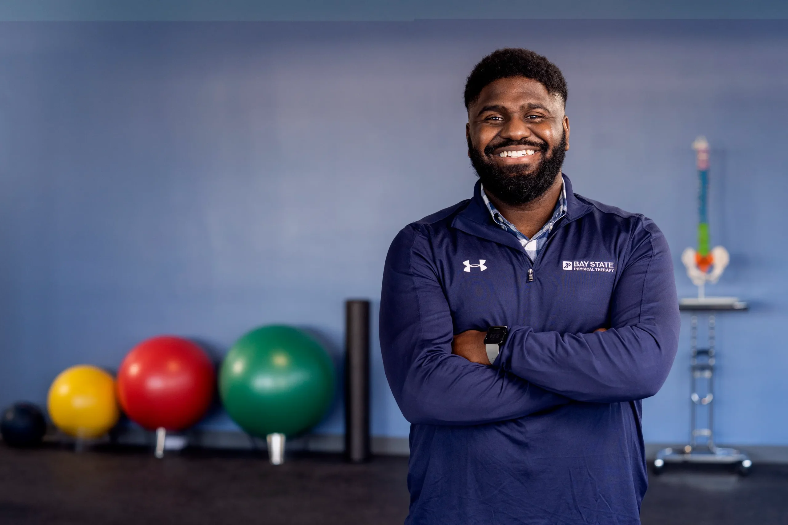A man poses outside a gym, encouraging winter healthcare planning for surgeries and physical therapy.