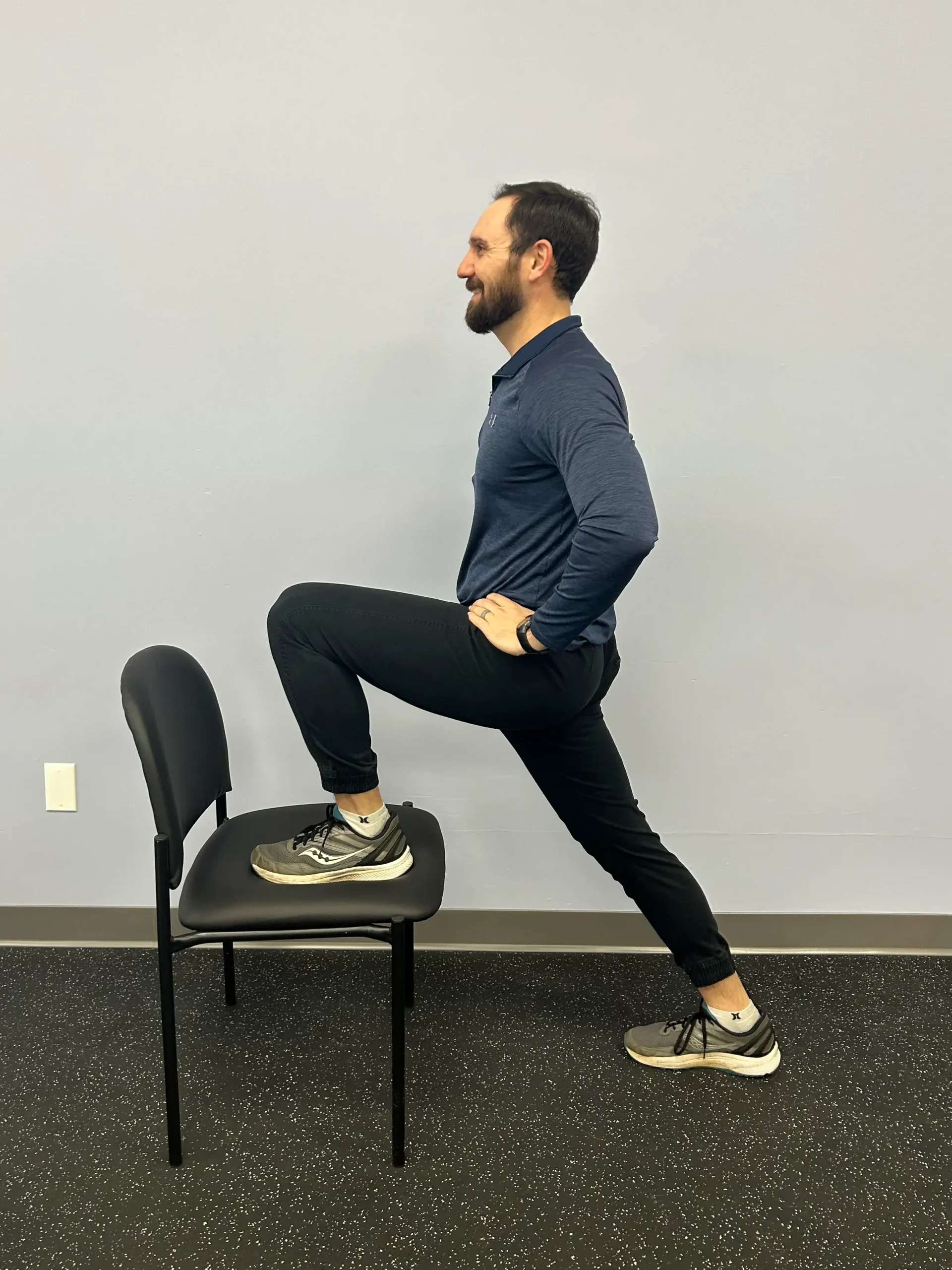 Man demonstrating Hip Flexor Stretch with chair.
