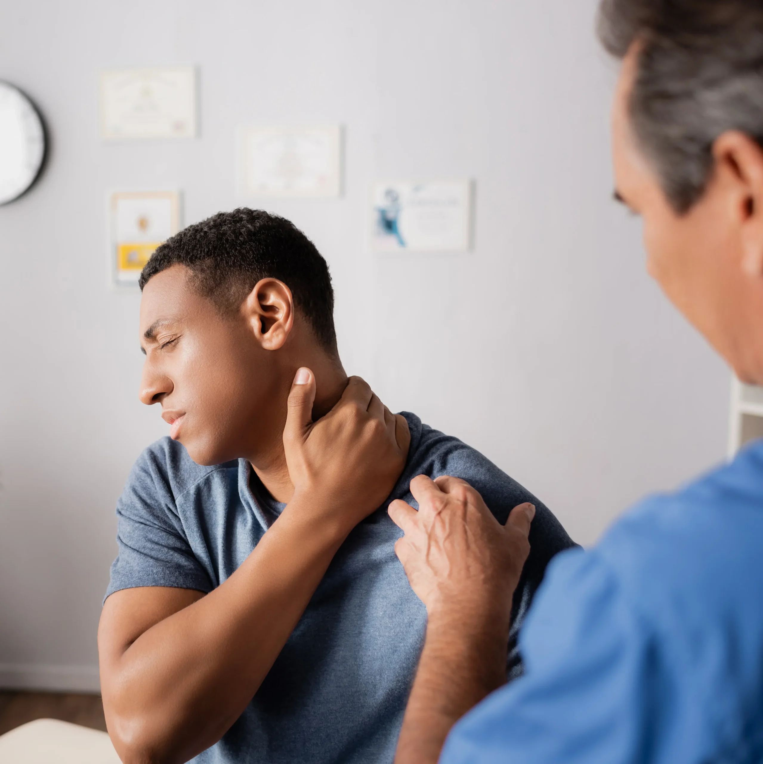 A doctor examines a man's neck, assessing for potential causes of neck pain such as strain or nerve issues.