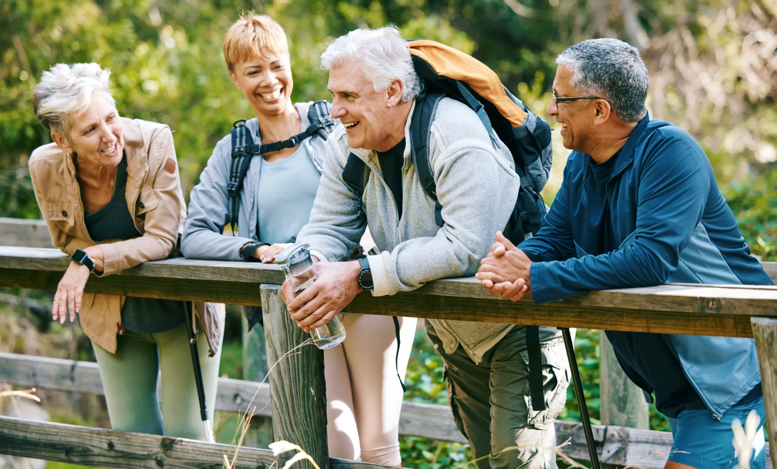group of four adults on an active adventure hiking in the woods.