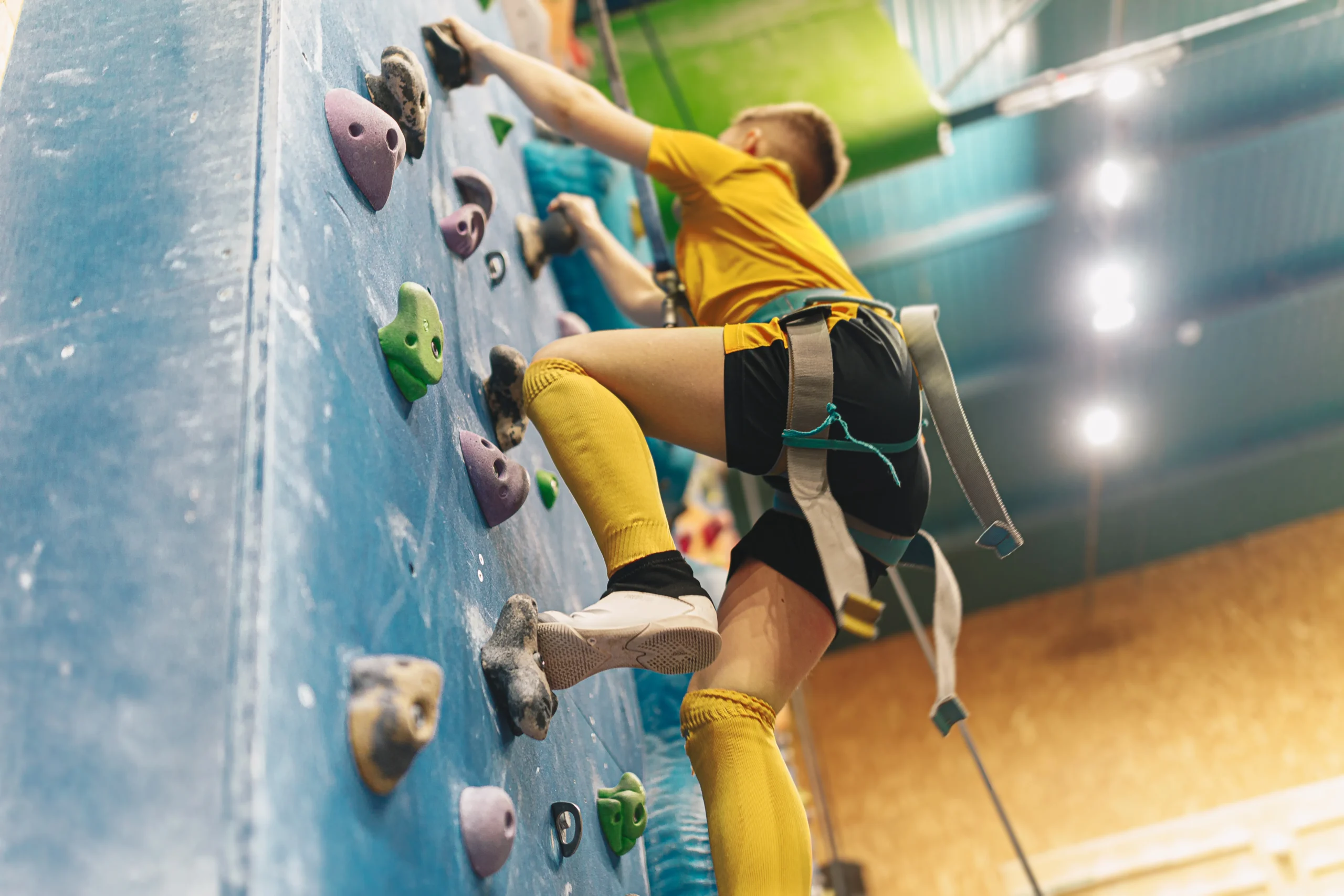 A man climbing a rock wall, showcasing strength and determination in an off-season training session.